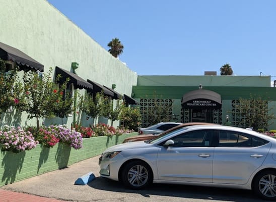 Exterior view of Arrowhead Healthcare Center with flowers and vehicles