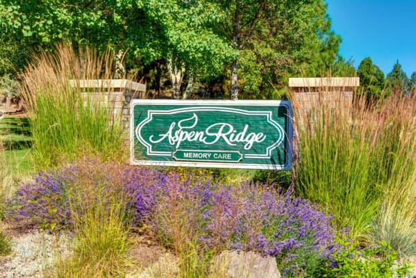 Sign for Aspen Ridge Memory Care surrounded by flowers