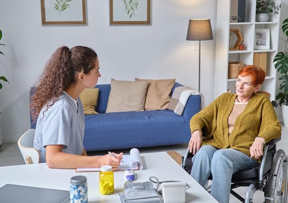 A caregiver and a resident having a discussion in a cozy living room.