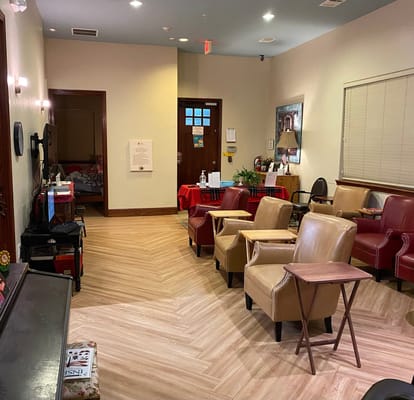 Common area with seating and television in memory care facility