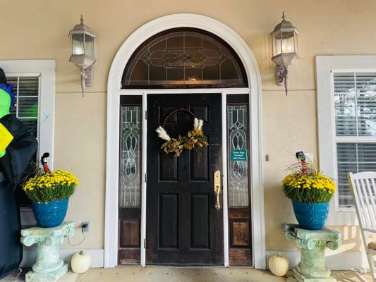 Front door adorned with seasonal decorations and flowers