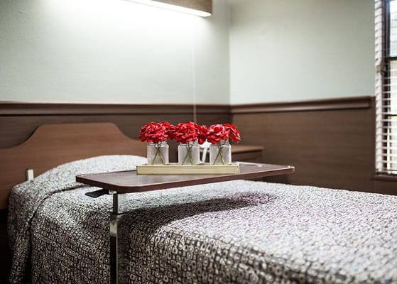 A cozy private resident room with flowers on a table
