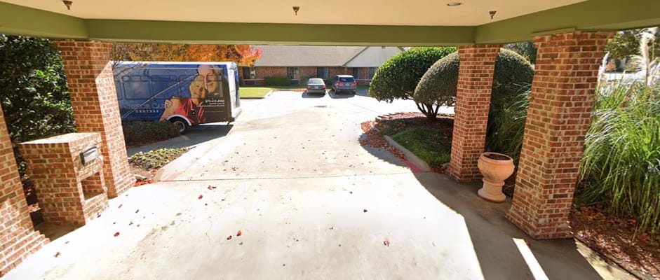 Entrance area with parked vehicles and landscaping