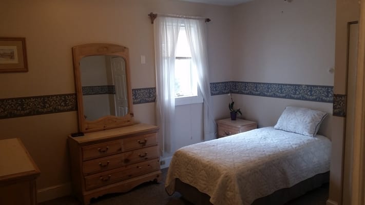 A single resident room with a bed and dresser