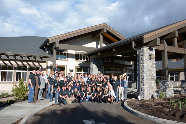 Group photo of staff in front of the facility