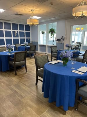 Dining room set up with blue tablecloths and flowers