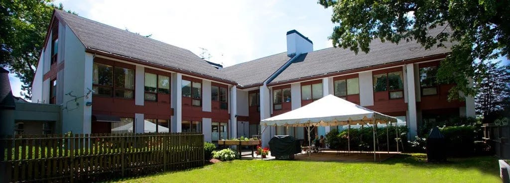 Exterior view of a senior living facility with outdoor seating