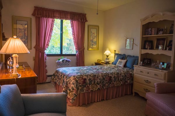 Cozy resident room with floral bedding and warm lighting