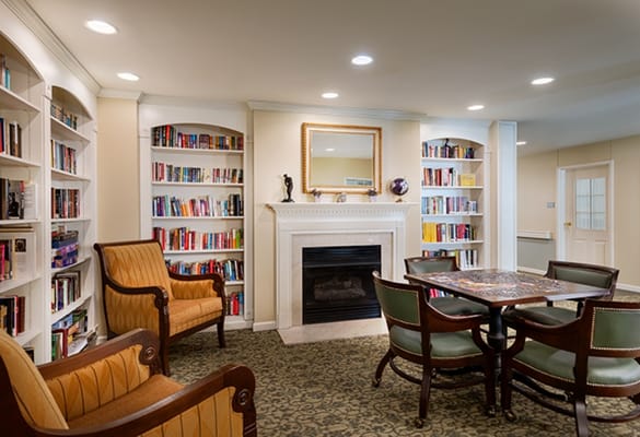 Cozy common area with bookshelves and a fireplace