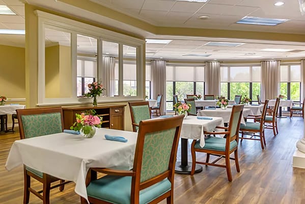 Bright dining area with tables and flowers