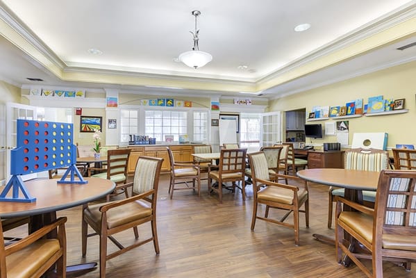 Bright common area with activity tables and art displays