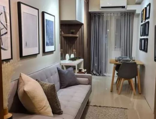 Elegant living room with gray sofa, artwork, and dining table.