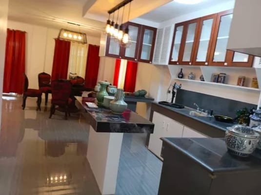 Bright kitchen and living area with red curtains and modern decor.