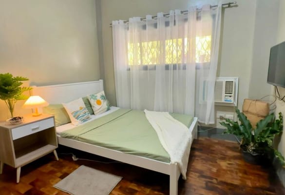 Cozy bedroom with a bed, side table, and curtains