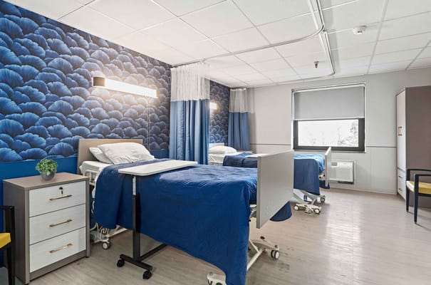 A well-lit interior of a resident room with three beds