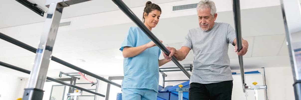 A caregiver assisting a resident during rehabilitation