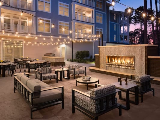 Outdoor seating area with fireplace and string lights