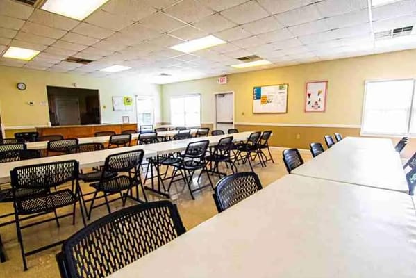 Bright common area with tables and chairs set up for activities