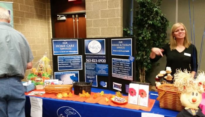 Staff member at a nursing home event with service displays
