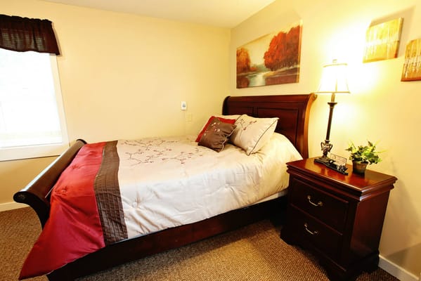 Cozy bedroom with a bed, lamp, and artwork