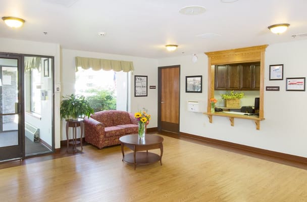 Bright lobby with a couch, coffee table, and reception area