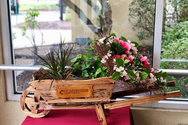 Decorative wheelbarrow with flowers in an indoor setting