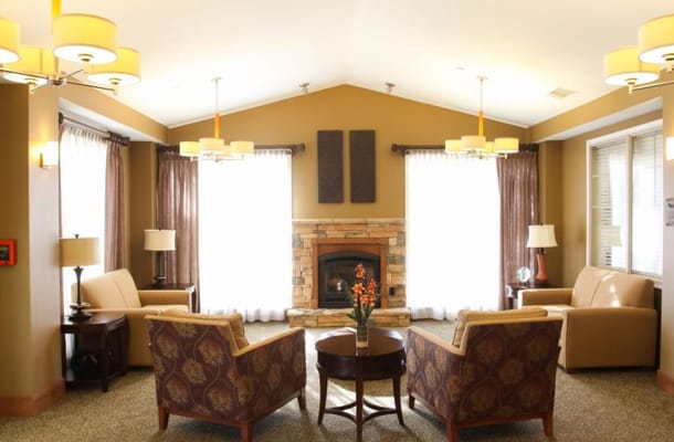 Lounge area with armchairs, a small table, and a fireplace