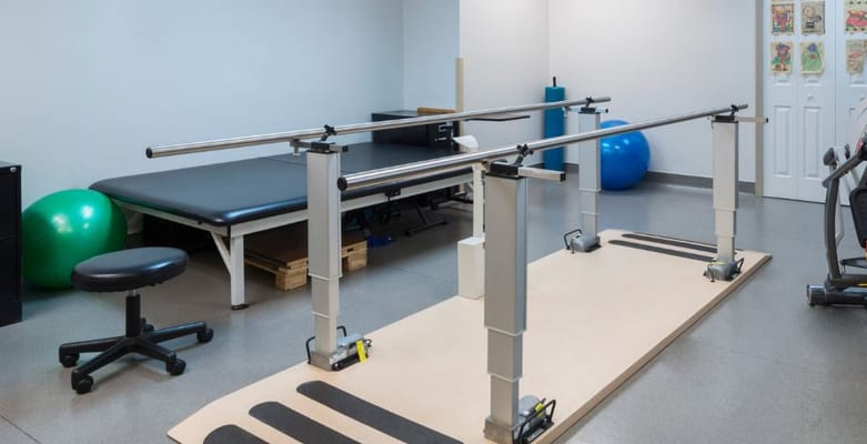 Rehabilitation therapy room with parallel bars and exercise equipment