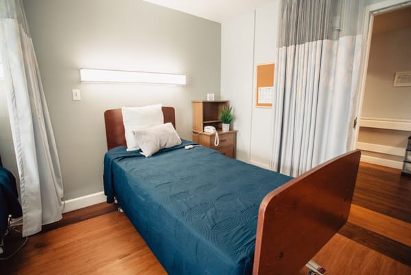 Cozy private room with a bed and side table