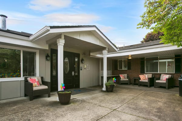 Exterior view of the entrance area with seating and flower pots.