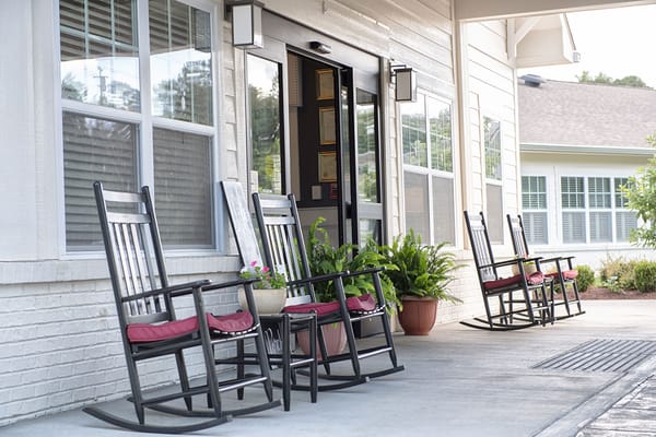 Rocking chairs on a porch outside a senior living facility