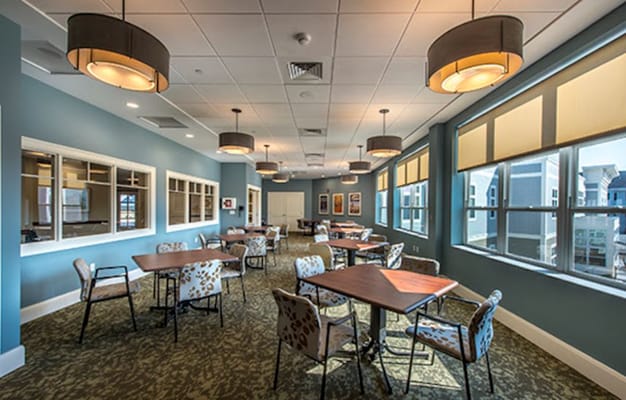 Brightly lit dining room with tables and chairs