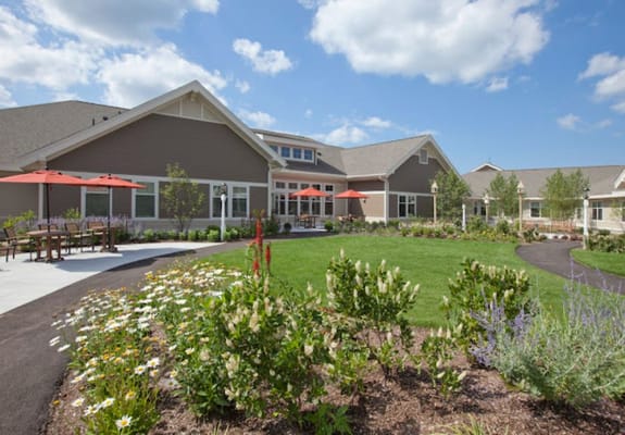 Outdoor garden with flowers and seating area at EPOCH Senior Living Waltham