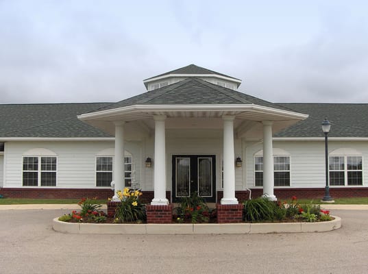 Main entrance of Eagle Springs senior living facility with landscaped garden.