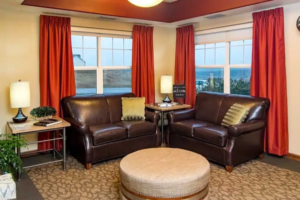 Comfortable seating area with two brown sofas and decorative lamps.