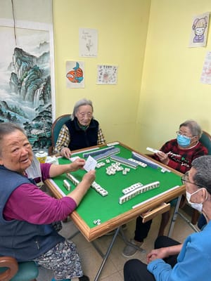 Residents playing mahjong in an activity room