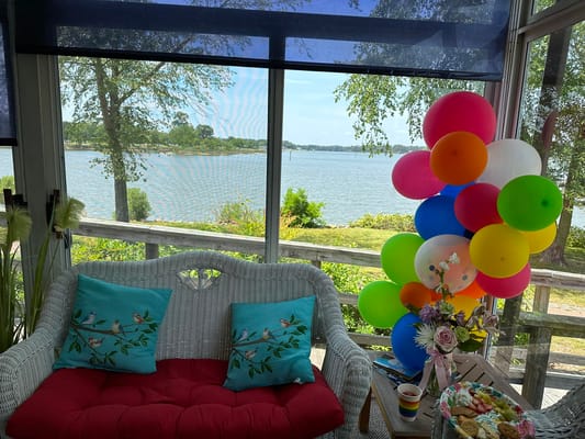 Bright sunroom with balloons and view of the lake