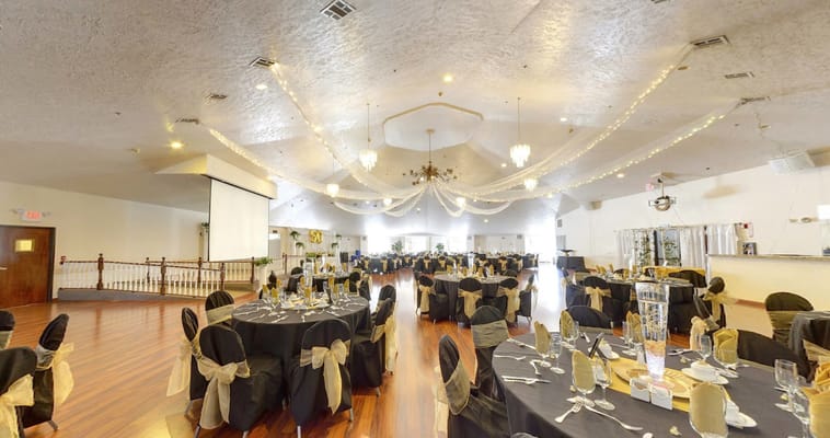 Spacious ballroom with decorated tables and chandeliers