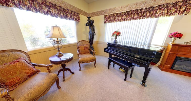 Cozy lounge featuring a black piano and elegant seating
