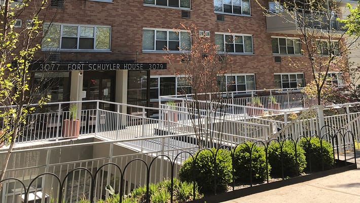 Entrance of Fort Schuyler House with ramp and greenery