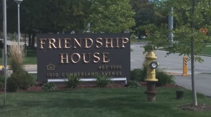 Sign for Friendship House Community on a street