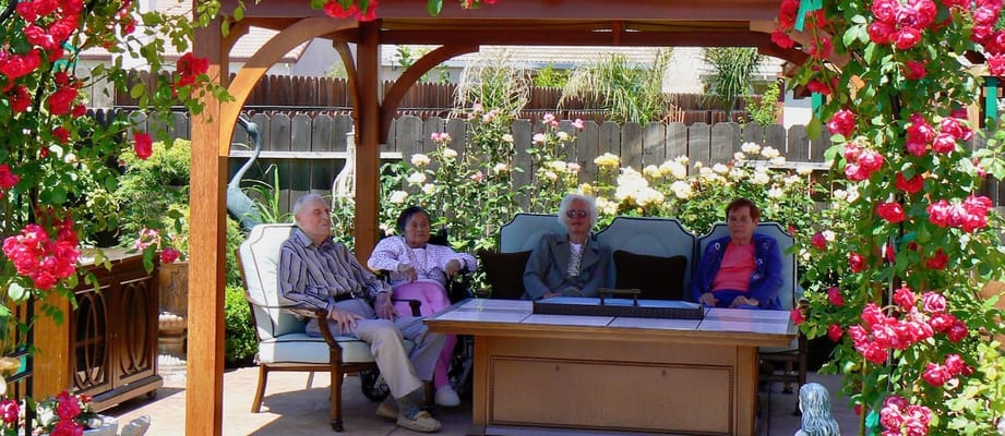 Residents enjoying the garden area with blooming roses