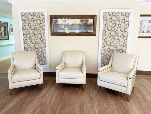 Three cream-colored chairs in a lounge setting