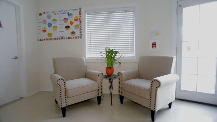 Cozy seating area with chairs and plant in a common room