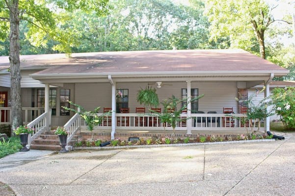 Front veranda of Green Oaks Inn with seating and plants