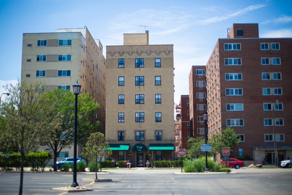 Exterior view of a senior living facility with green awnings