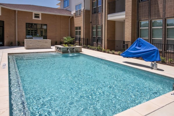 Outdoor pool area with water features and lounge space