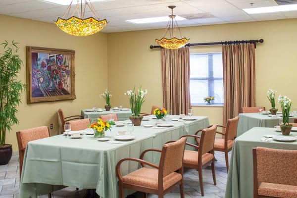 Brightly lit dining room with tables set for meals