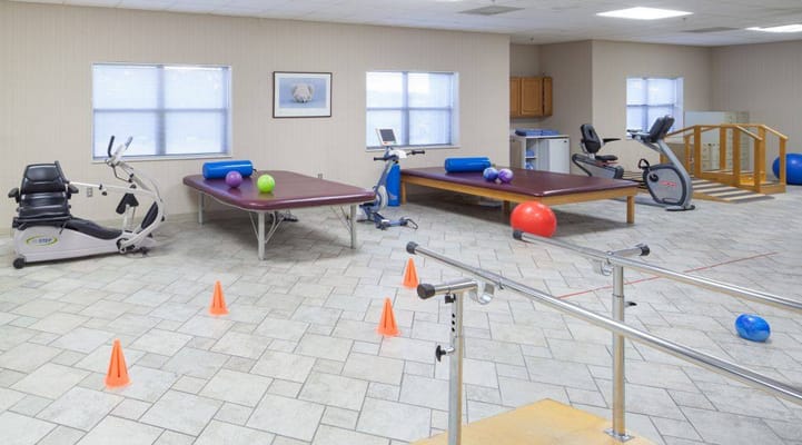 Interior of the therapy room featuring exercise equipment and therapy tables.