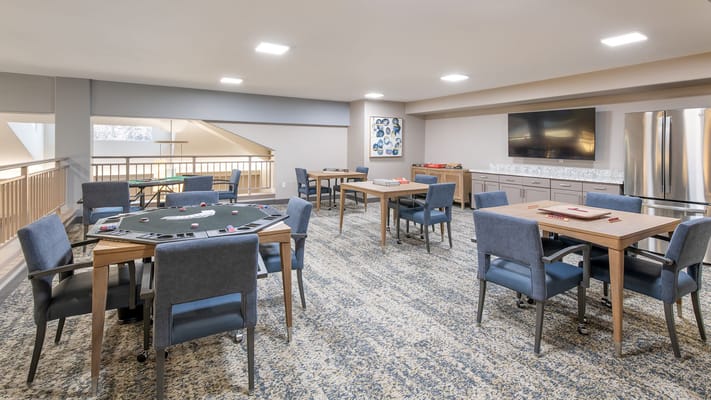 Bright activity room with gaming tables and chairs